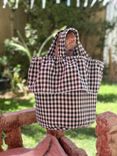 Load image into Gallery viewer, Black and white checkered strollee basket bag on a stone bench outdoors