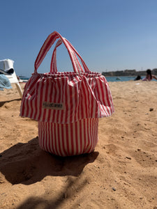 Load image into Gallery viewer, Red and white striped bag stroller basket on a sandy beach
